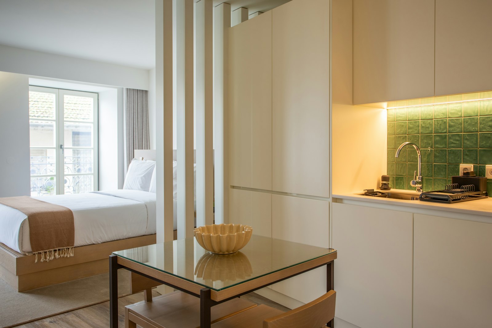 Petit studio avec un lit et une table, typique d'un logement étudiant