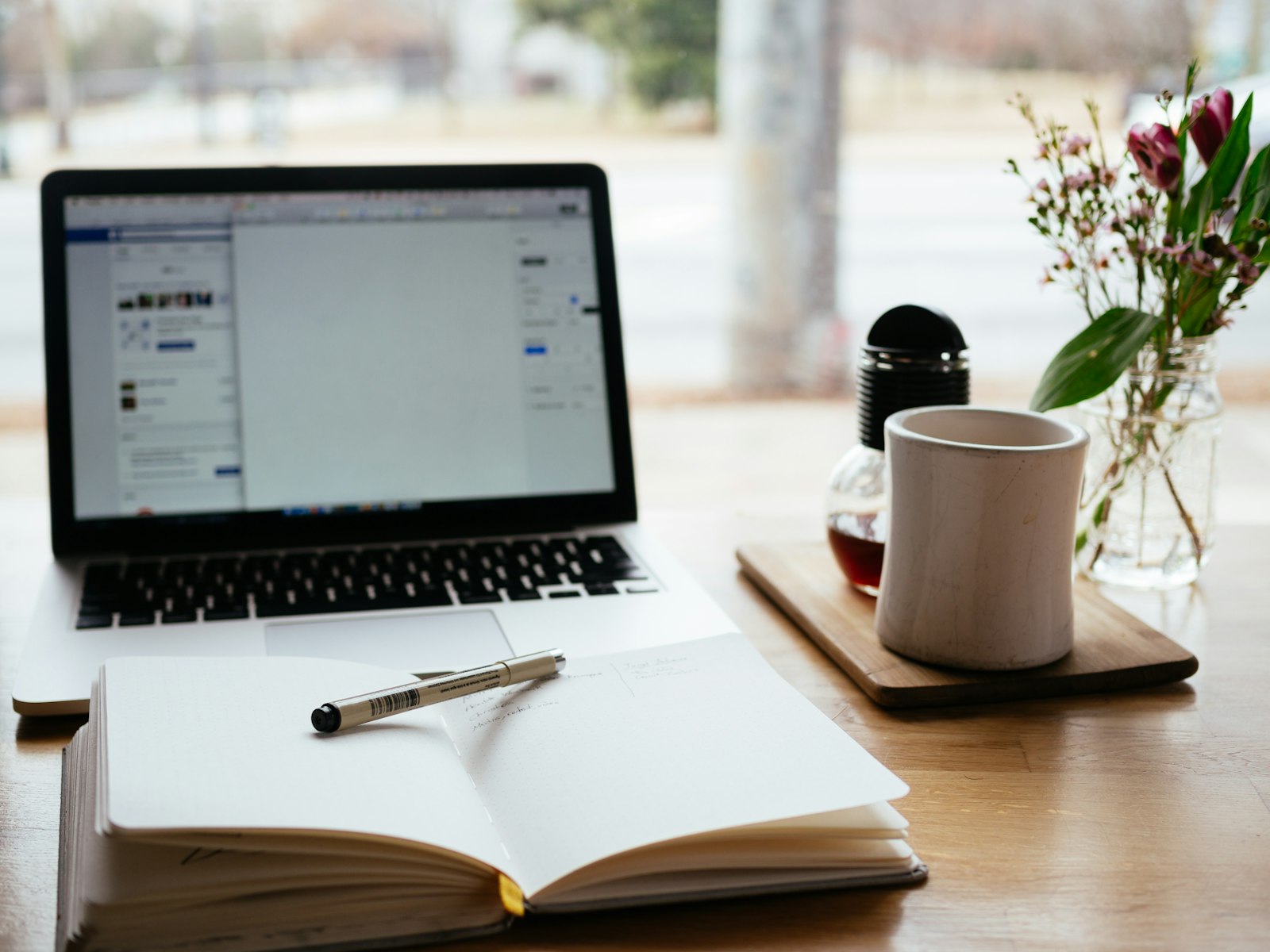 Ordinateur portable et carnet de notes ouvert sur un bureau de travail